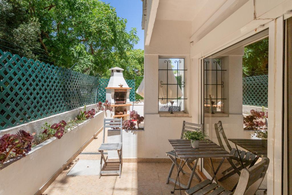 a balcony with chairs and a table and a grill at BeGuest Gandarinha Apartment in Cascais