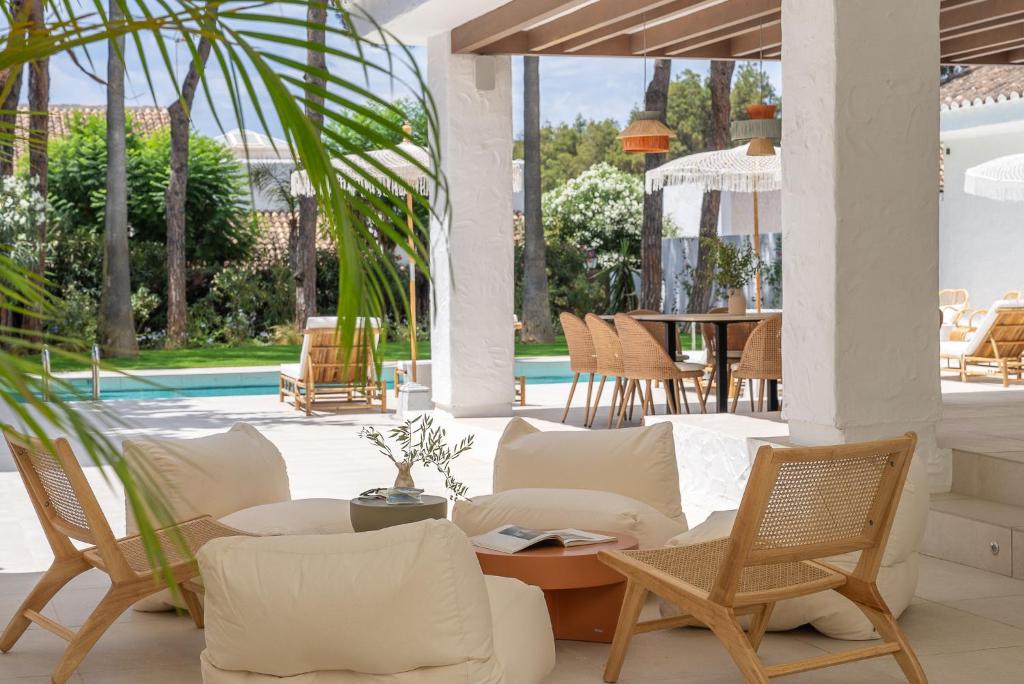une terrasse avec des chaises, une table et une piscine dans l'établissement Anfitrión Villas & Suites, à Marbella