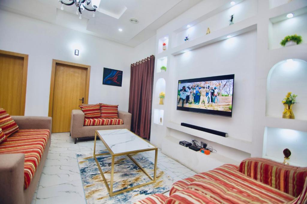 萊基的住宿－Oasis Villa Lekki，客厅配有两张沙发和一台电视机