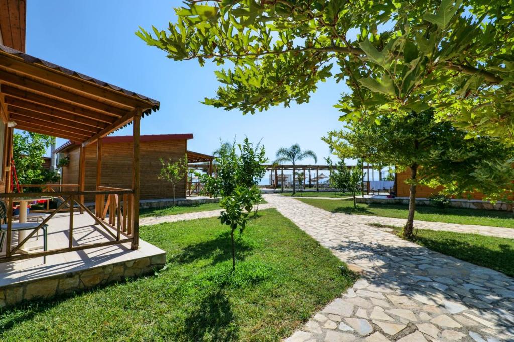 a walkway next to a house with a tree at Bunec Beach Resort in Piqeras