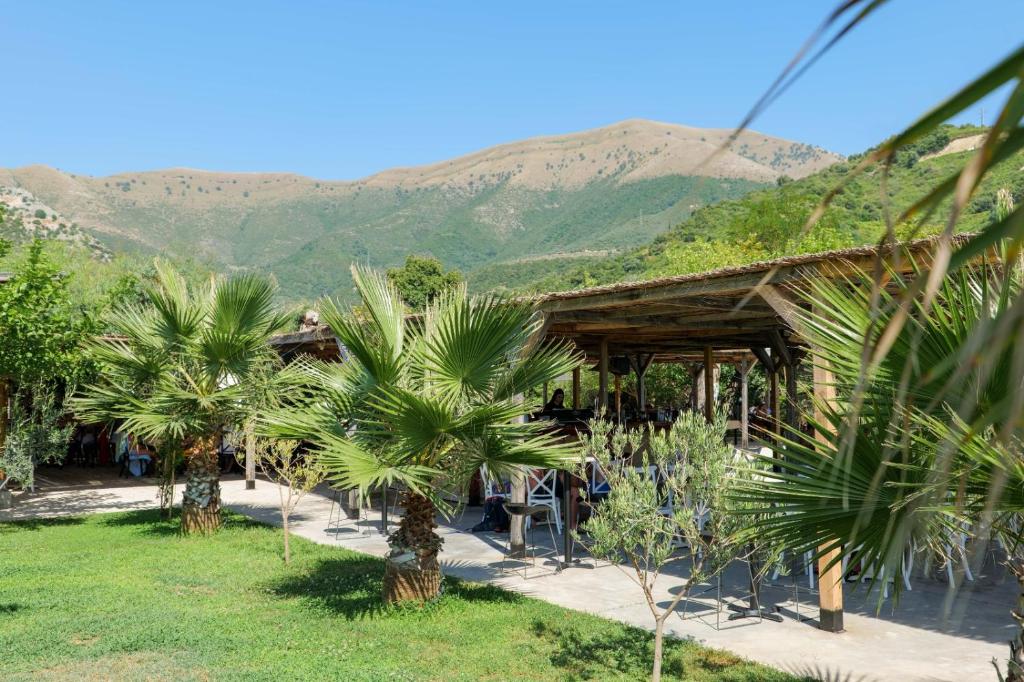 a resort with palm trees and mountains in the background at Bunec Beach Resort in Piqeras