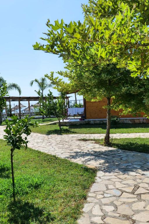 a stone walkway with a tree in a park at Bunec Beach Resort in Piqeras