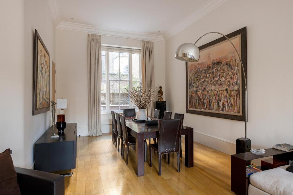 sala de estar con mesa de comedor y sofá en Maisonette Hyde Park, en Londres