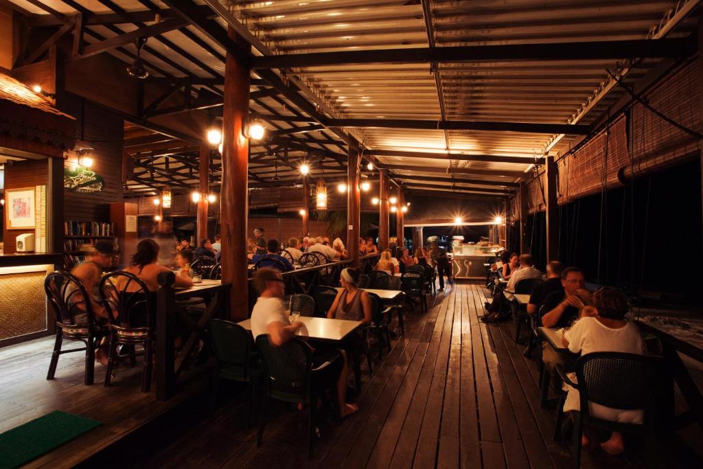 a group of people sitting at tables in a restaurant at Tuna Bay Island Resort in Perhentian Islands
