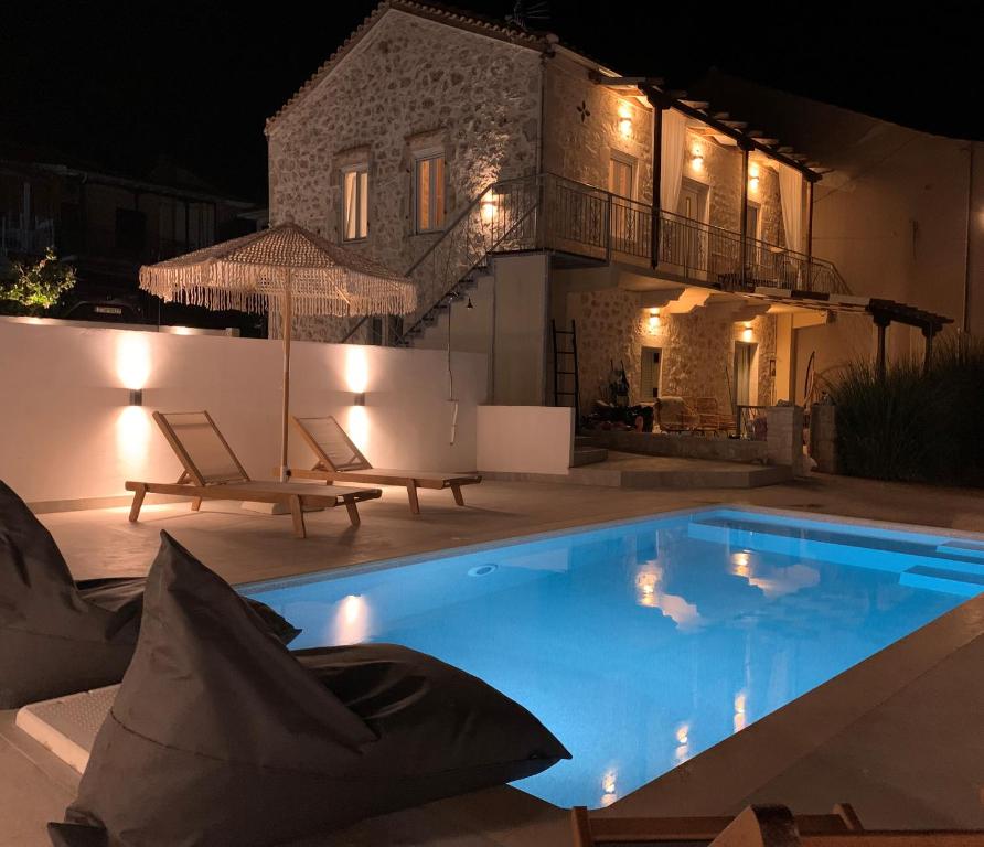 a swimming pool in front of a house at night at Mangata suites homes with private pools in Meganisi
