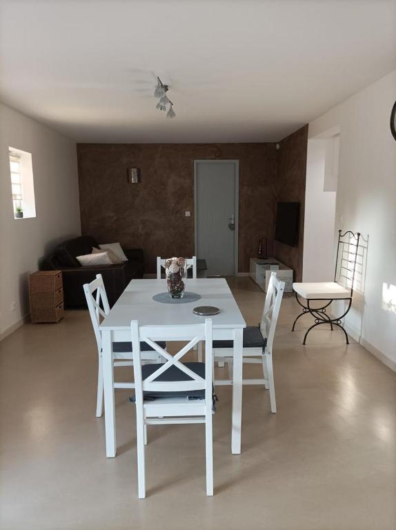 une table blanche et des chaises dans un salon dans l'établissement Les Pins, à Saint-Martin-dʼAoût