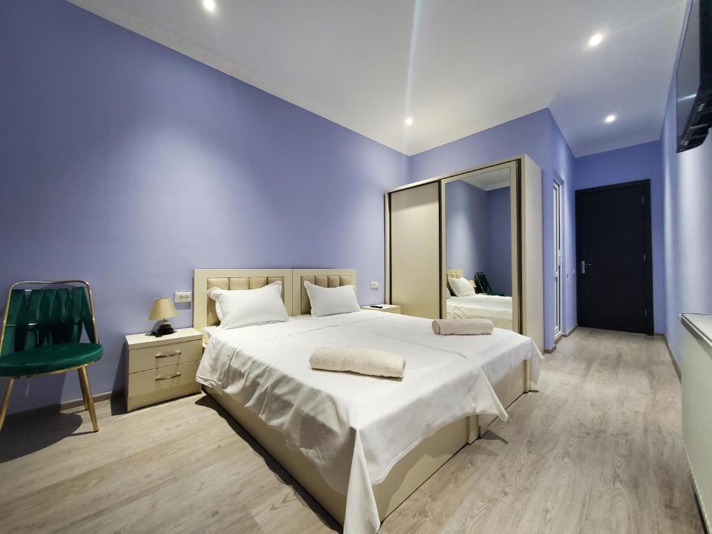 - une chambre bleue avec un grand lit et un miroir dans l'établissement Hotel N, à Tskhaltubo