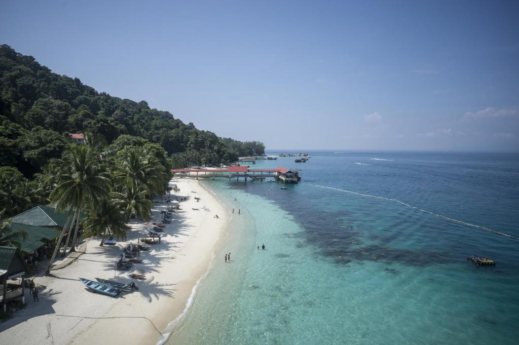 an aerial view of a beach with palm trees and the ocean at Tuna Bay Island Resort in Perhentian Islands