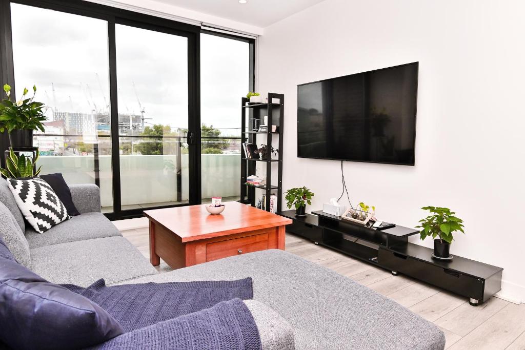 a living room with a couch and a flat screen tv at Contemporary Comfort in Melbourne