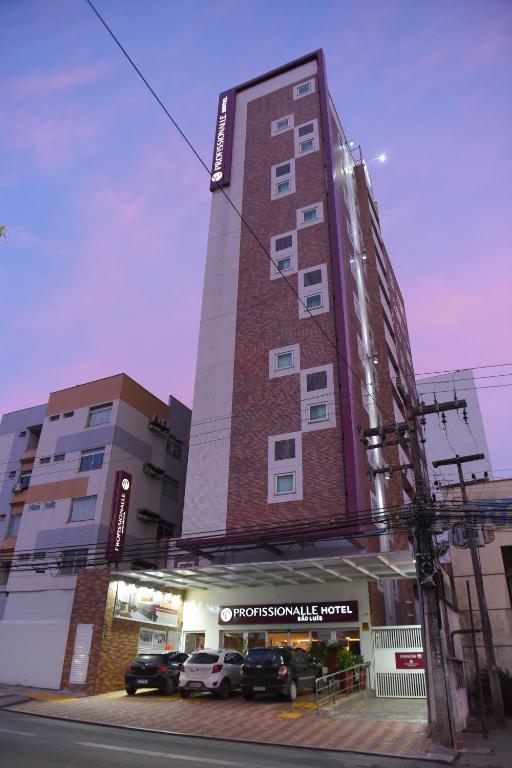 サンルイスにあるProfissionalle Hotel São Luísの前に車が駐車されている高い建物