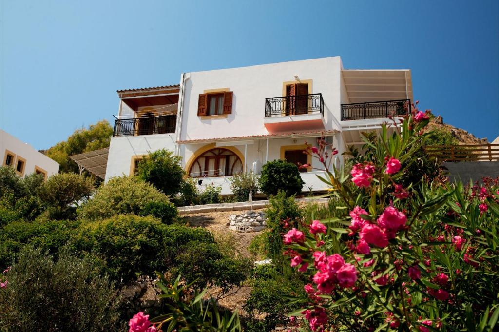 a white house with pink flowers in front of it at Yvonni Studios in Patmos