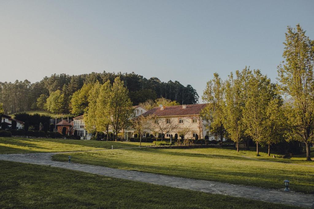 a group of houses in a field with trees at Amalurra Ecohotel & Retreat Center in Laiseca