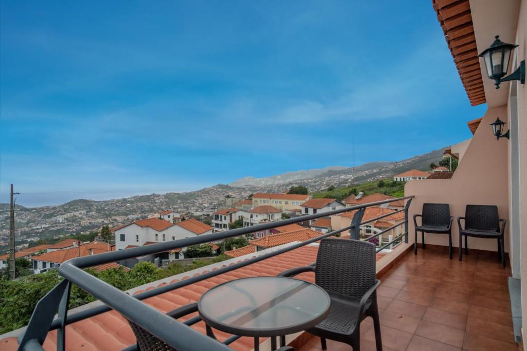 balcón con mesa, sillas y vistas en Casa Monte, en Funchal