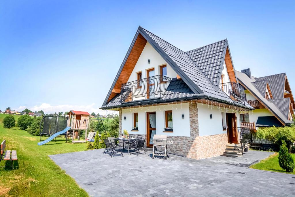 a house with a patio and a playground at Domki u Górala in Zakopane