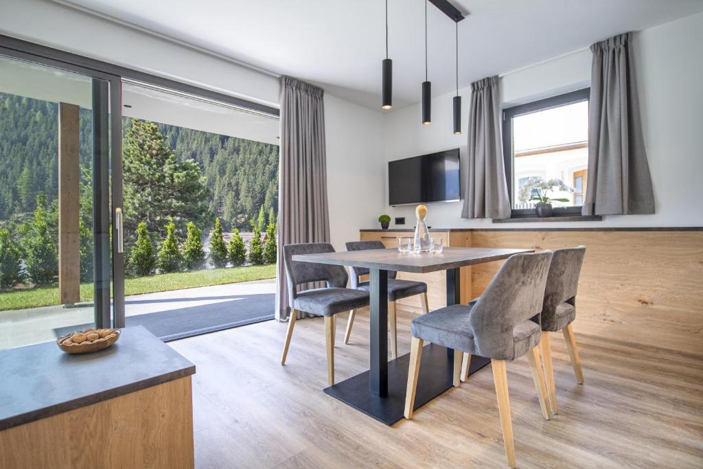 - une cuisine et une salle à manger avec une table et des chaises dans l'établissement Apartments Chalet Silva, à Selva di Val Gardena