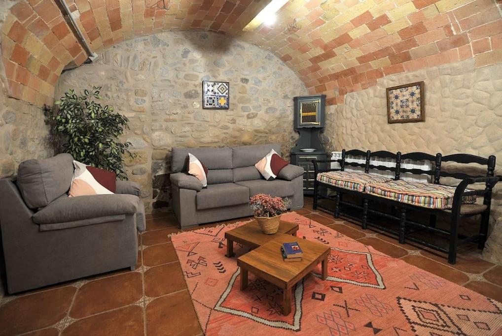 a living room with two couches and a table at Casa del silencio Can Baldoyra in Espinavesa