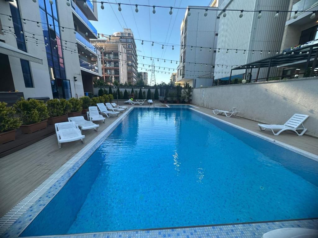 a large blue swimming pool with lounge chairs on a building at Family Inn in Gonio