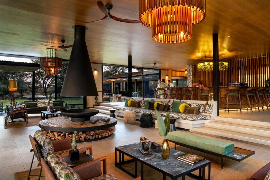 ein großes Wohnzimmer mit Sofas und Tischen in der Unterkunft Tanda Tula Safari Camp in Timbavati Game Reserve