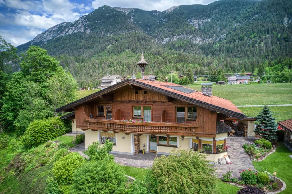 an image of a house with mountains in the background at Appartments Geisler in Achenkirch