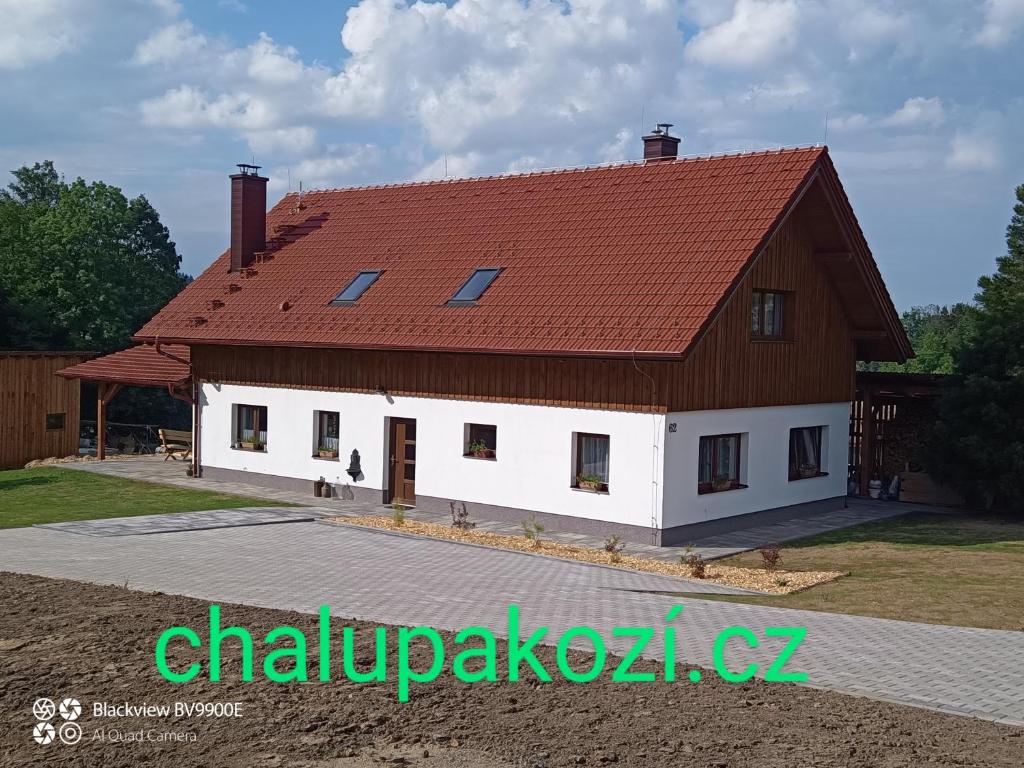una gran casa blanca con techo rojo en Chalupa Kozí 62, en Klatovy
