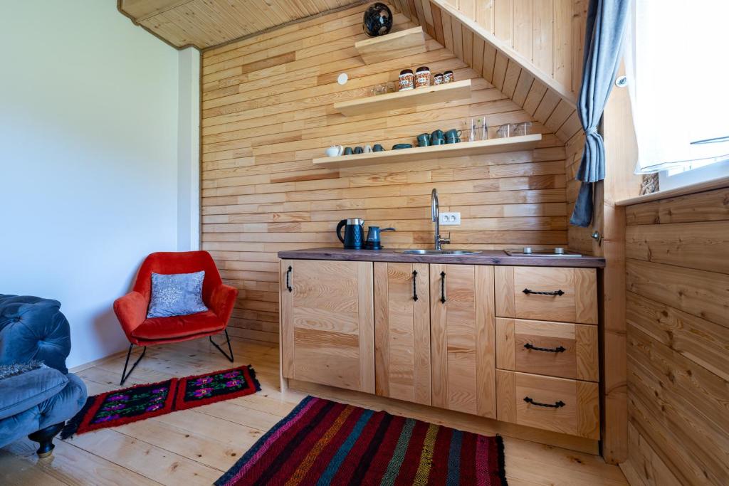bagno con lavandino e sedia rossa di Apartments CENTER OF THE WORLD a Žabljak