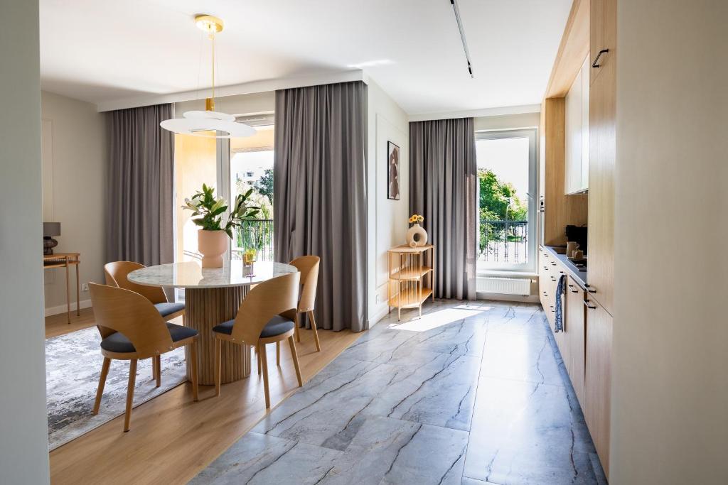 a kitchen and dining room with a table and chairs at Apartament Zoja II in Elblag