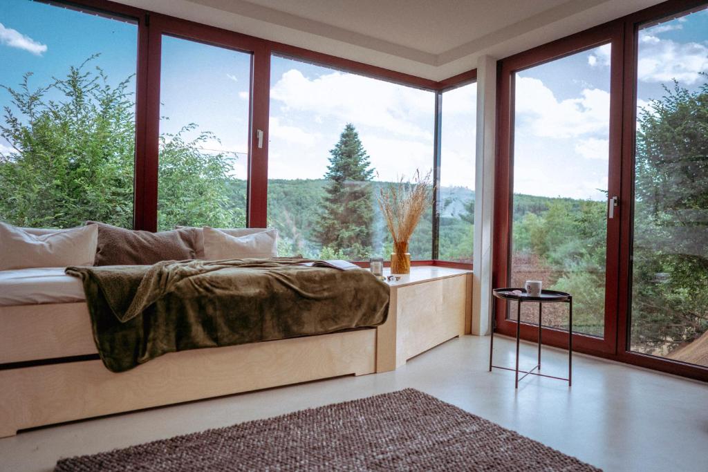 a bedroom with a bed and large windows at Chata nad Kocábou in Štěchovice