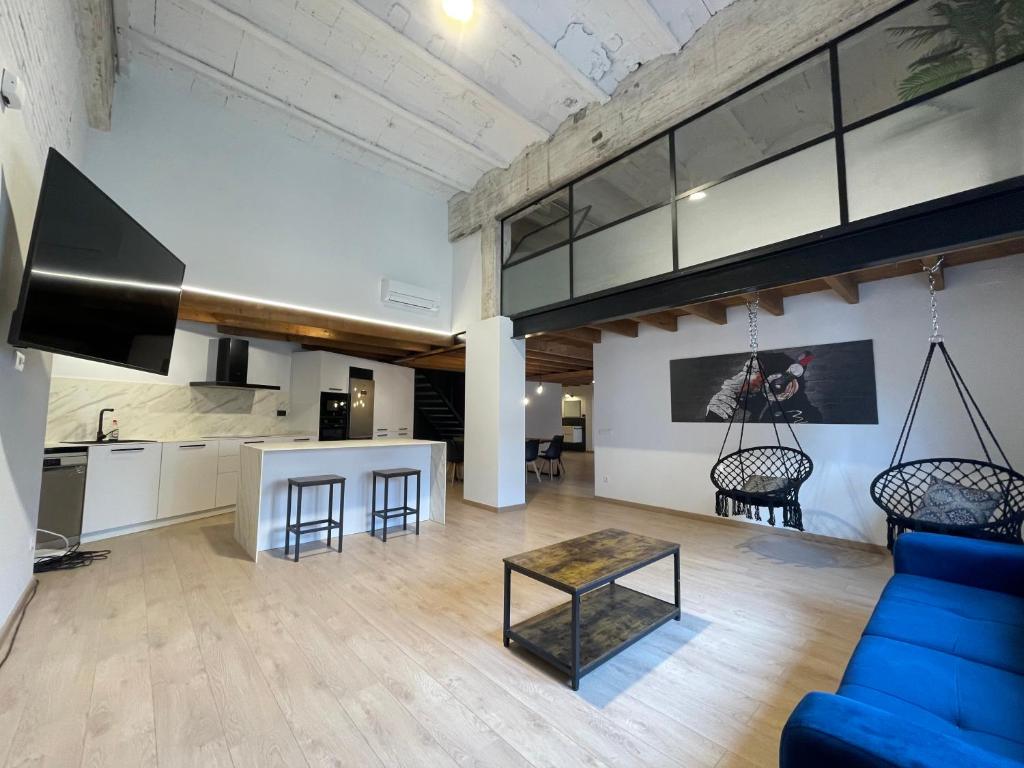 ein Wohnzimmer mit einem blauen Sofa und einem Tisch in der Unterkunft Manresa industrial home in Manresa