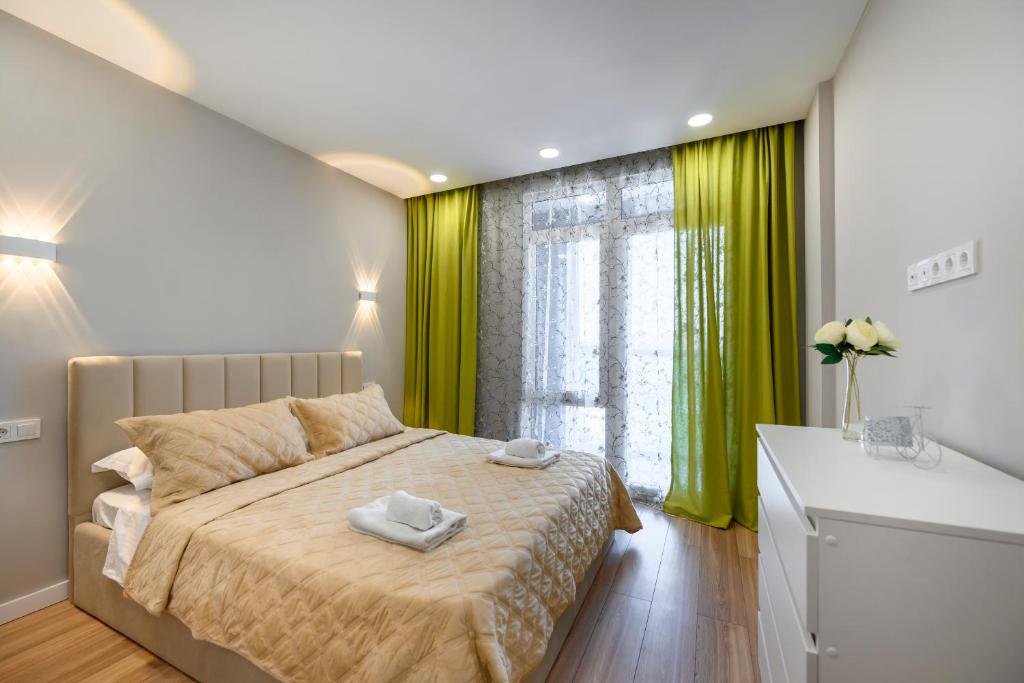 1 dormitorio con 1 cama y una ventana con cortinas verdes en Уютная двушка по улице Абая, en Almaty