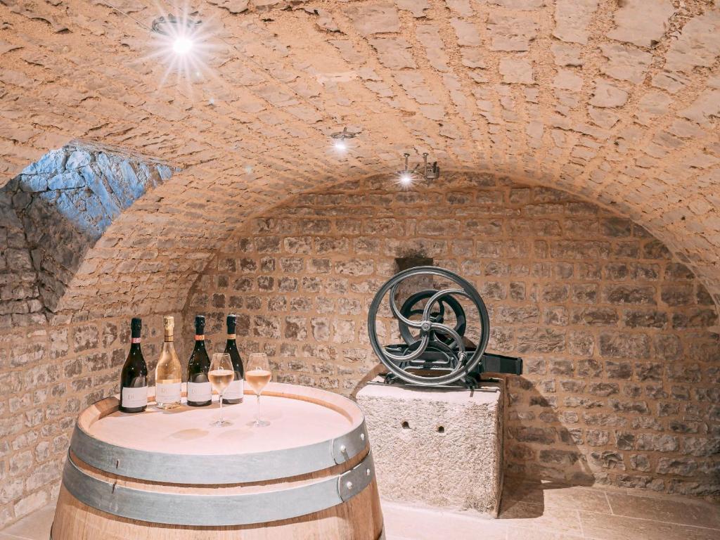 - une salle de dégustation de vins avec des bouteilles de vin et une roue dans l'établissement Villa Eulalie B&B Guest House nestled in the Champagne area, à Bligny