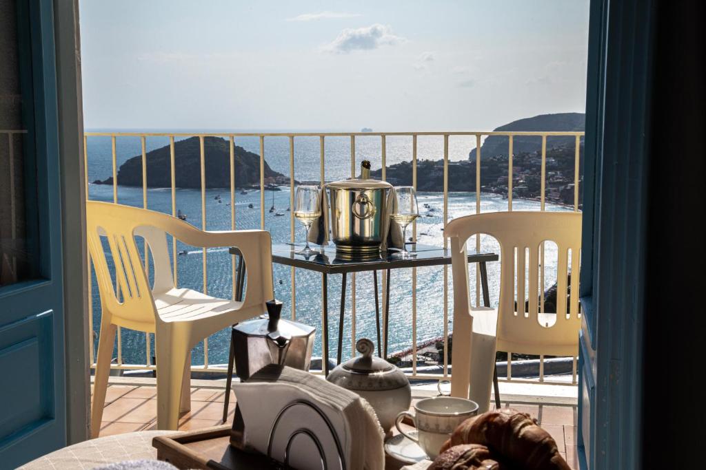 einen Balkon mit 2 Stühlen und einem Tisch mit Meerblick in der Unterkunft Hotel Sunset Green in Ischia