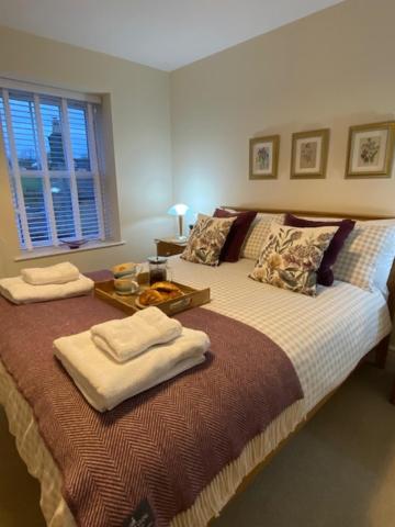 a bedroom with a large bed with towels on it at Two Ways in Tansley