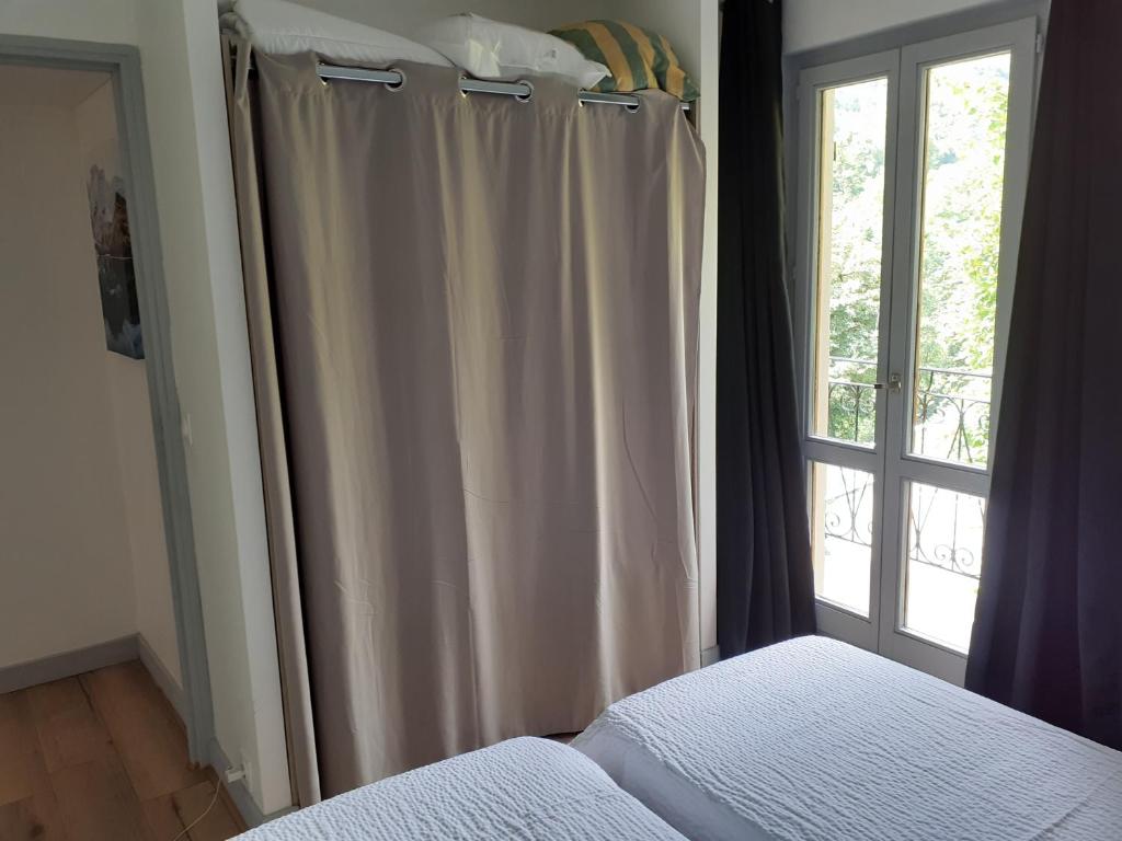 a bedroom with a bed and a window at LA DOVA MARMOTTE in Brides-les-Bains