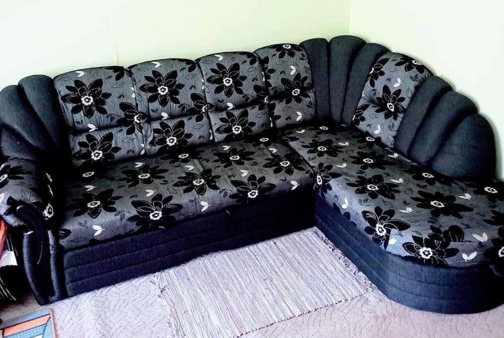 a black couch with black flowers on it at Quite House in Liepāja