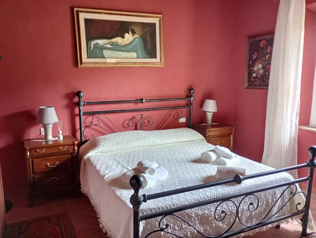 um quarto com uma cama e um quadro na parede em La Casa Rossa em Coiano
