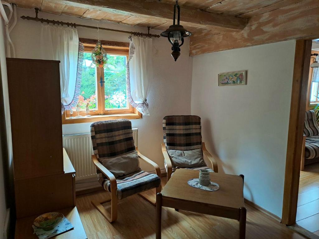 a living room with two chairs and a table and a window at Kamélie in Česká Kamenice