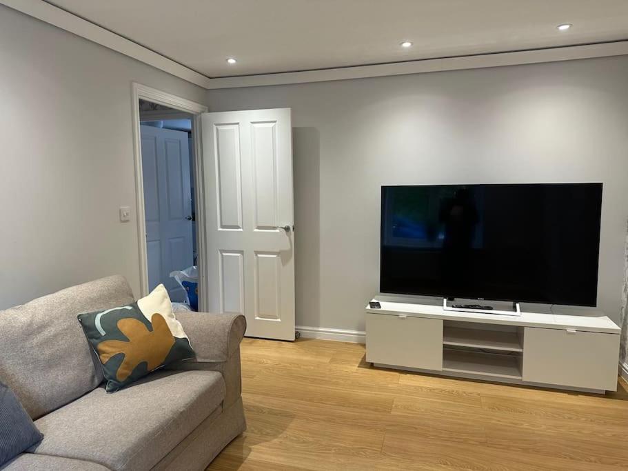 a living room with a large flat screen tv at Stunning 4-Bedroom Home in Basingstoke