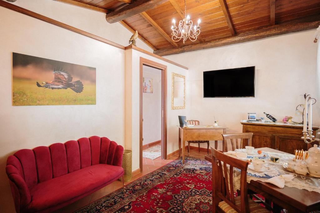 Lago del Turano - Guest House il Nido dell'Aquila في Ascrea: غرفة معيشة مع أريكة حمراء وطاولة