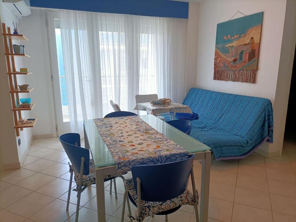 - un salon avec une table et un canapé bleu dans l'établissement Amazing apartment for 6 person with sea view terrace by Beahost Rentals, à Bibione