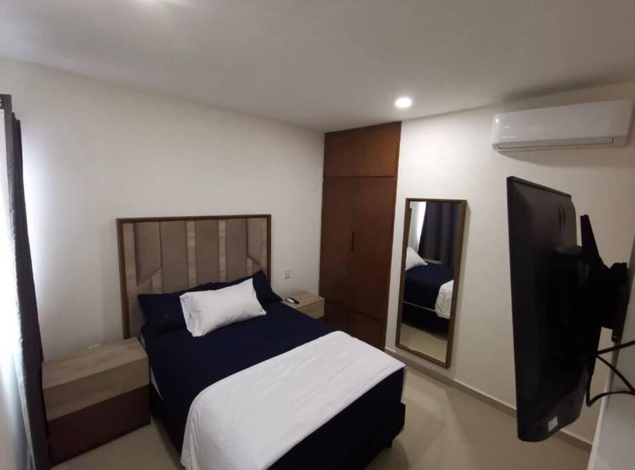 um quarto de hotel com uma cama e um espelho em Hermoso alojamiento vacacional em Mazatlán