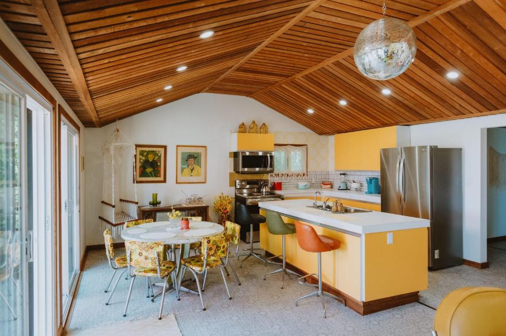 Il comprend une cuisine avec des plafonds en bois, une table et des chaises. dans l'établissement 1970s retro vibe - The Creamsicle - Lake Huron Oliphant, à Wiarton
