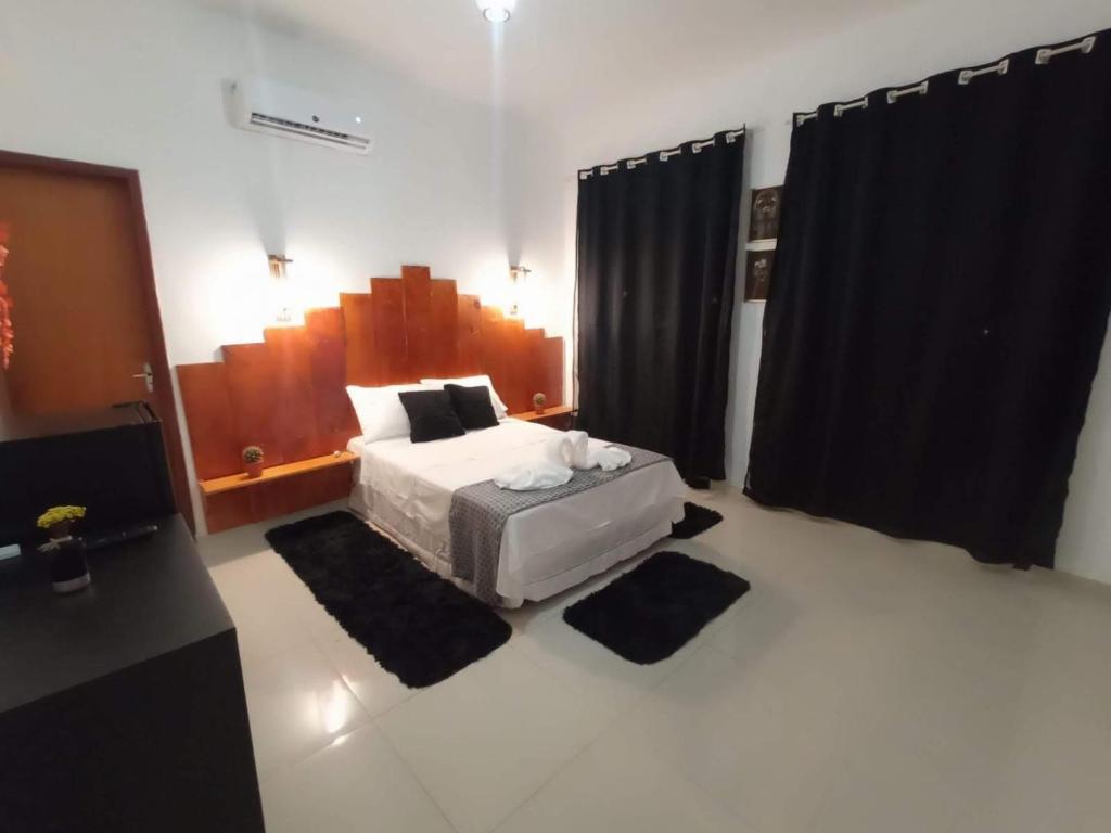 1 dormitorio con cama y cortinas negras en Central Palace Hotel, en Fortaleza