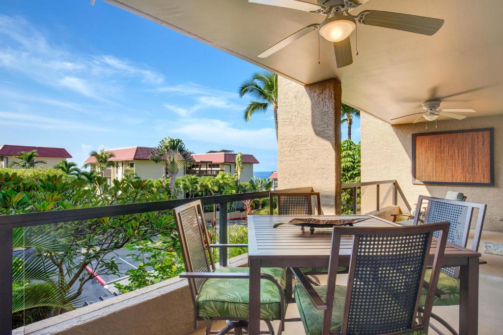 a patio with a table and chairs on a balcony at Kona Pacific D524 Kauhale in Kailua-Kona