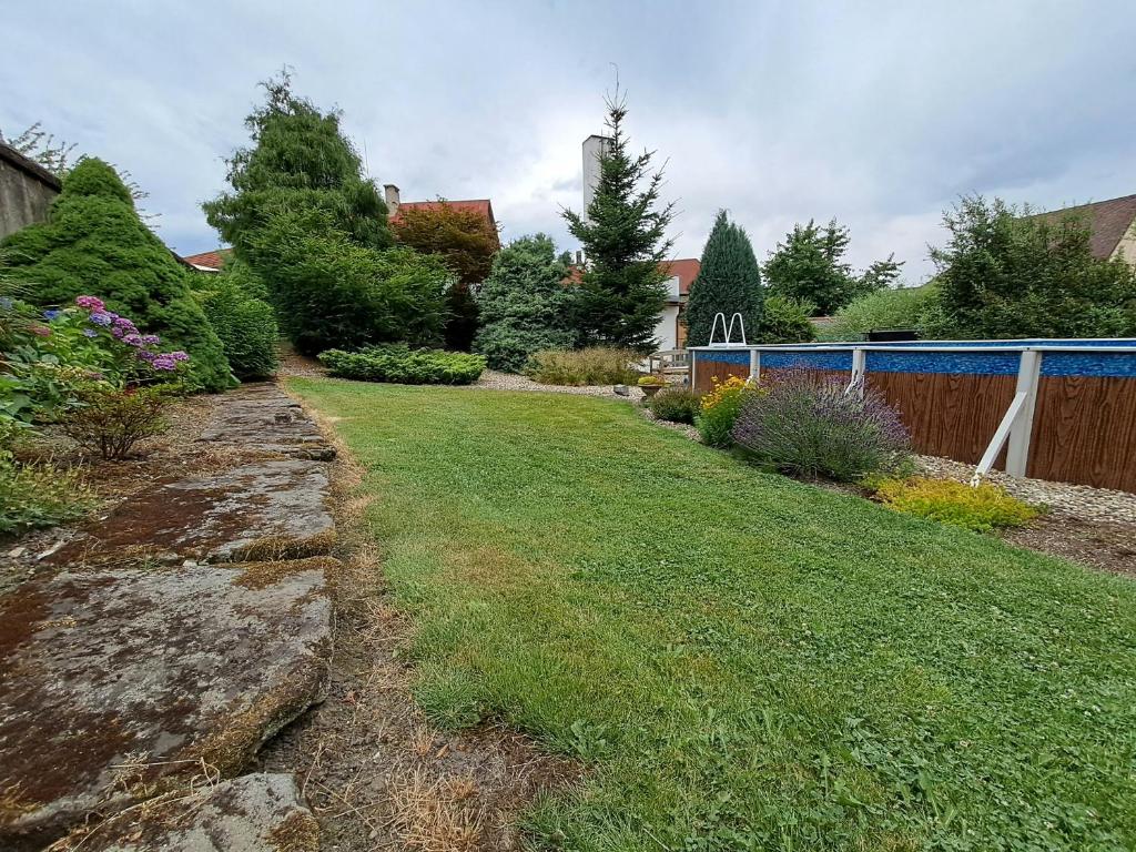 a yard with a lawn with a fence and trees at Kamélie in Česká Kamenice