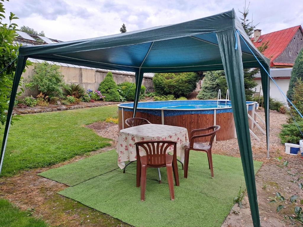 a table and chairs under a canopy in a yard at Kamélie in Česká Kamenice