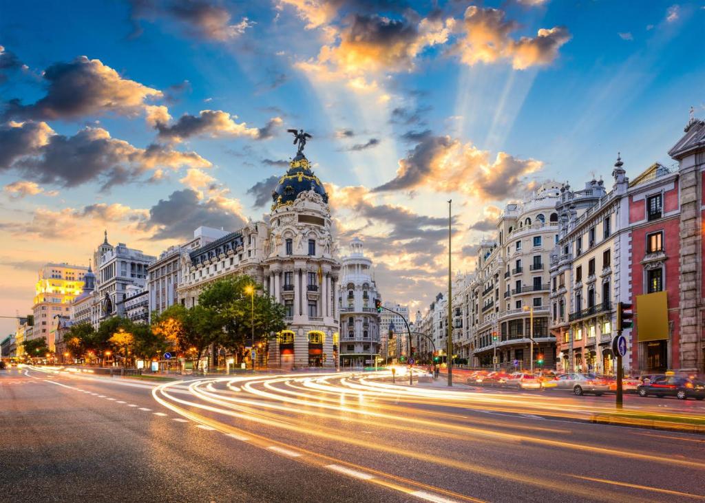 une rue de la ville au crépuscule avec un bâtiment dans l'établissement Puerta del Sol -de la Cruz Isabel I0 & Parking, à Madrid