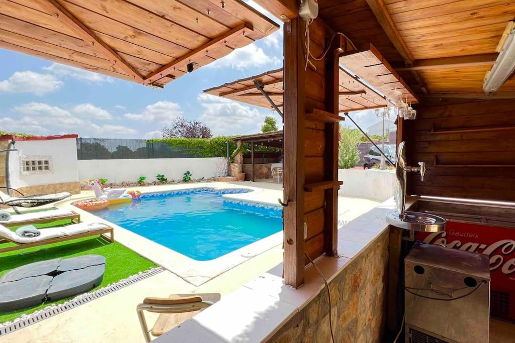 a swimming pool in a backyard with a wooden roof at Monserrat vista unica in Carme