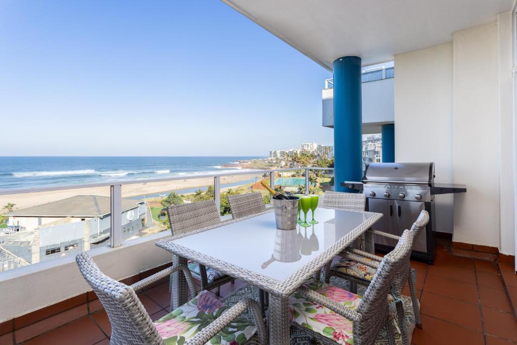 a dining room with a table and chairs and the beach at Colonial Sands 403 in Margate