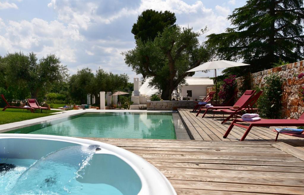 una piscina con bañera de hidromasaje en una terraza de madera en IL TRULLO BIANCO - Country House & SPA, en Castellana Grotte