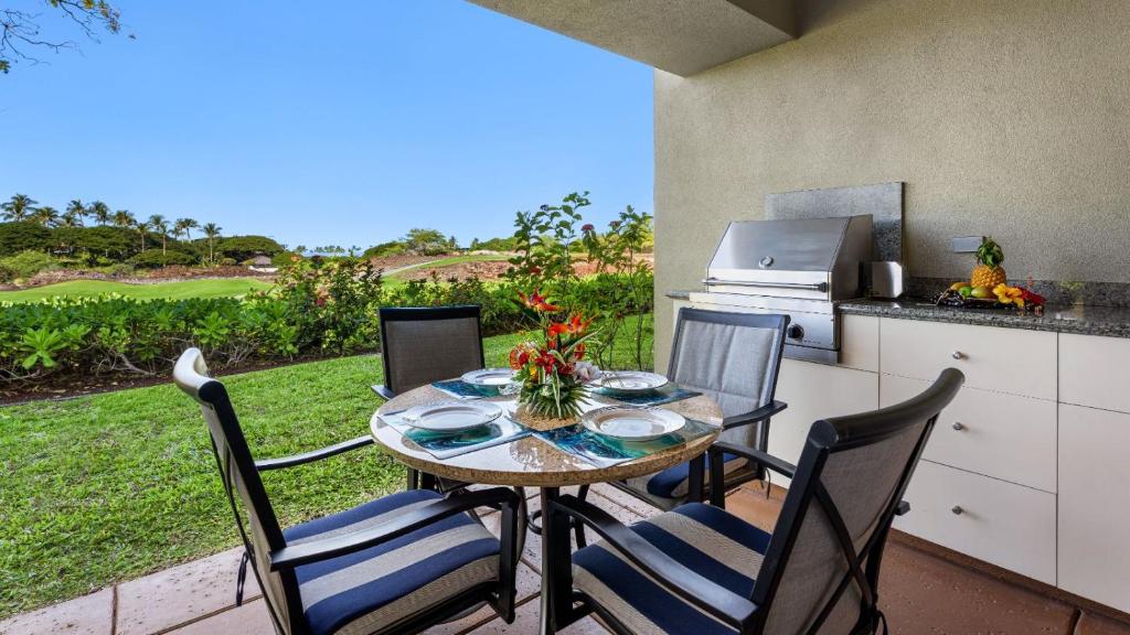 a patio with a table and chairs and a kitchen at Mauna Lani Fairways 903 in Waikoloa